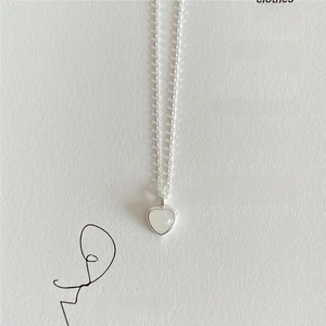 Close-up of minimalist sterling silver heart necklace with white pearl shell inlay