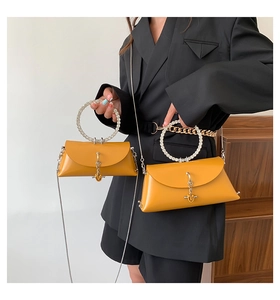 Detail of ginger yellow jelly bags with sparkling rhinestone circular handles and chains