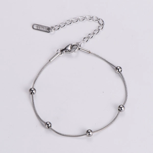 Detail of silver stainless steel snake chain bracelet with beads and 18KGR tag
