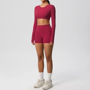 Detail of dark red seamless yoga set featuring long sleeve crop top and high waist shorts