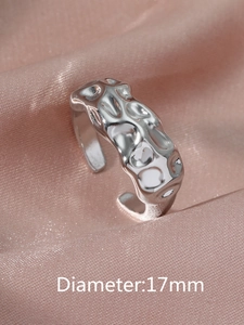 Detailed view of silver irregular liquid metal ring on pink silk with 17mm diameter info