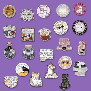 Collection of colorful enamel cat pins and metal badges on a purple background