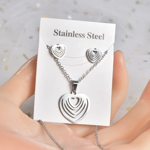 Macro view of heart-shaped stainless steel necklace and earrings set on display card