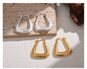 Detailed macro view of minimalist U-shaped geometric earrings in gold and silver finish