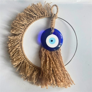 Detail of bohemian handmade crescent moon wall hanging with blue evil eye pendant