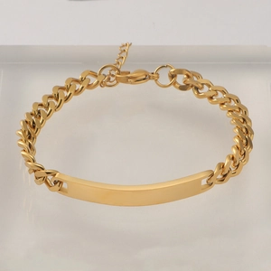 Detailed view of golden stainless steel Cuban link bracelet with adjustable ID plate