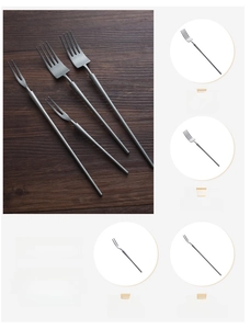Detail of matte silver-grey stainless steel forks set on a dark wood background