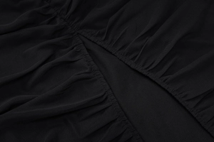 Detailed close-up of sheer black mesh fabric with elegant pleated texture and ruching