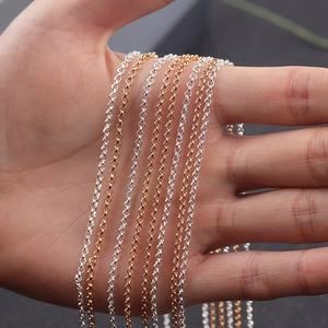 Detalle de cadenas de eslabones cubanos de acero inoxidable en plata y oro en la mano