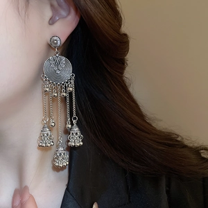 Close-up of vintage silver hoop earrings with metallic fringe on model
