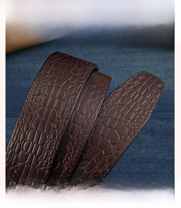 Macro shot of dark brown genuine cowhide leather belt featuring sharp crocodile texture