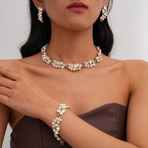 Baroque style gold jewelry set featuring pearls and crystals worn by a model