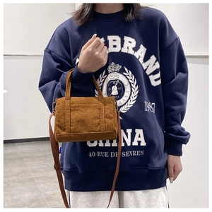 Caramel corduroy Boston bag shown being held by a model to display size and fit
