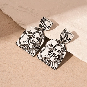 Macro shot of abstract line art female portrait on acrylic drop earrings with stone texture