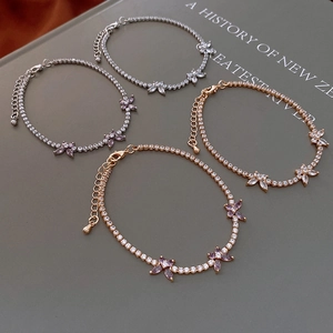 Detail of zircon butterfly bracelets in silver and rose gold on a vintage book