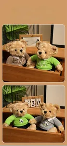 Close-up of teddy bears wearing knitted sweaters with panda prints and M embroidery