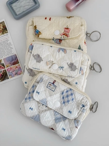 Detail of quilted pouches with animal prints and front snap pockets on white background