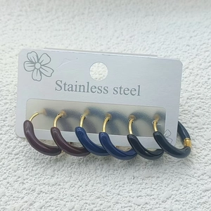 Detailed set of three pairs of stainless steel hoop earrings in brown, blue, and black