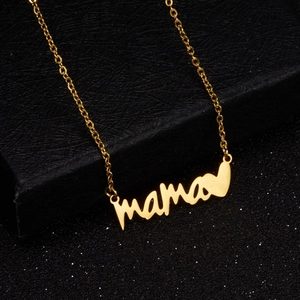 Detail view of a gold Mama pendant necklace with heart symbol on a black jewelry box