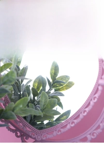 Close-up of pink heart-shaped makeup mirror with intricate European embossed floral details