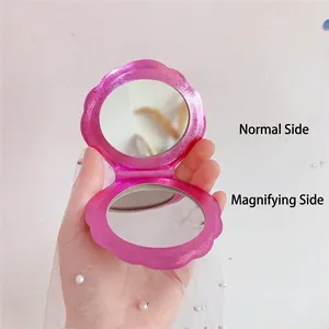 Pink shell shaped pocket mirror with double sided 1x and magnifying vanity lenses