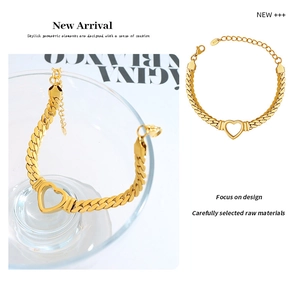 Macro detail of a gold-plated heart snake chain bracelet with polished hollow heart charm