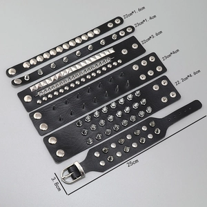 Set of 6 punk leather bracelets with silver metal spikes and studs on a grey background