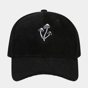 Close-up of three white mushrooms embroidery on black corduroy baseball cap texture
