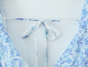 Detailed view of the V-neck lace-up back design with blue floral porcelain print