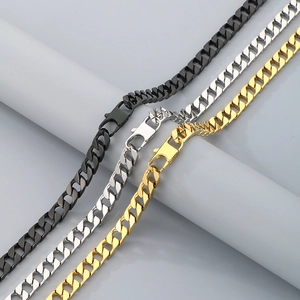 Detailed close-up of Cuban link necklaces in black, silver, and gold steel finish