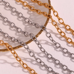 Polished 18K gold and silver stainless steel cross chains displayed on a decorative plate