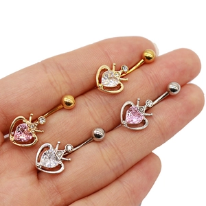 Détail de piercings de nombril couronne cœur avec zircons roses et clairs en or et argent