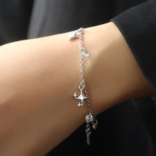 Close-up of double-layer silver bracelet with star pendants worn on a female wrist