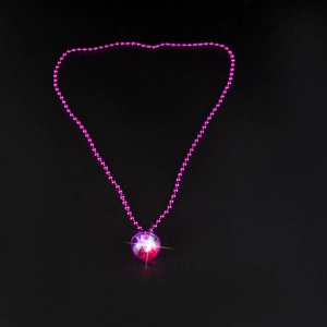 Close-up of a glowing 70s disco ball pendant necklace with pink LED lights and magenta beads