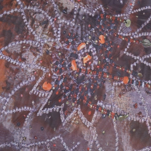 Vue macro détaillée du tissu en maille brodé avec perles colorées et broderie délicate