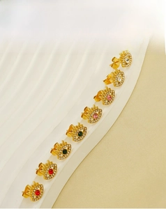 Detailed view of evil eye stud earrings with colorful zircons and gold plated finish
