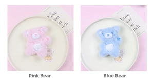 Close-up of cute pink and blue plush bears with heart embroidery on beige tray