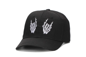 Close-up of white skeleton hand embroidery on black cotton twill baseball cap
