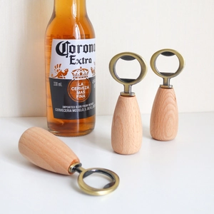 Detailed view of three solid wood magnetic bottle openers with a beer bottle accessory