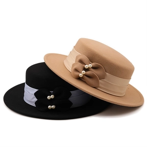 Détail de chapeaux en feutre de laine avec ruban de soie, nœud et perles élégantes