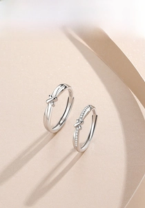 Macro detail of S925 sterling silver couple rings with knot design and micro-pave stones