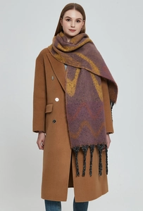 Detail of burgundy wavy knit shawl with thick tassels and warm mohair-like texture