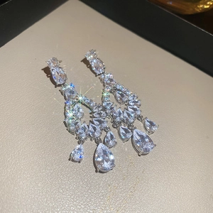 Detail of silver drop earrings with pear-cut cubic zirconia in a beige jewelry box