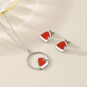 Detailed view of Christmas hat necklace and earrings set with red and white enamel finish