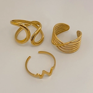 Detailed view of three gold adjustable stainless steel rings in wave and heart rate designs