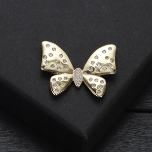 Détail macro d'une broche papillon dorée ornée de zircons sur une boîte cadeau noire