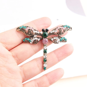 Detailed close-up of a vintage dragonfly brooch with colorful rhinestones and bronze alloy