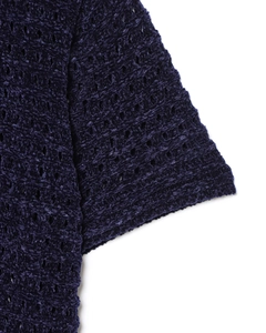 Dettaglio della trama traforata all'uncinetto del top in maglia blu scuro da donna