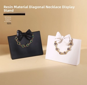Detail of resin necklace stands with elegant bows in matte black and white finishes