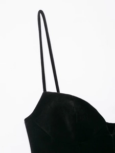 Détail des fines bretelles et de la texture douce du velours noir sur une robe courte